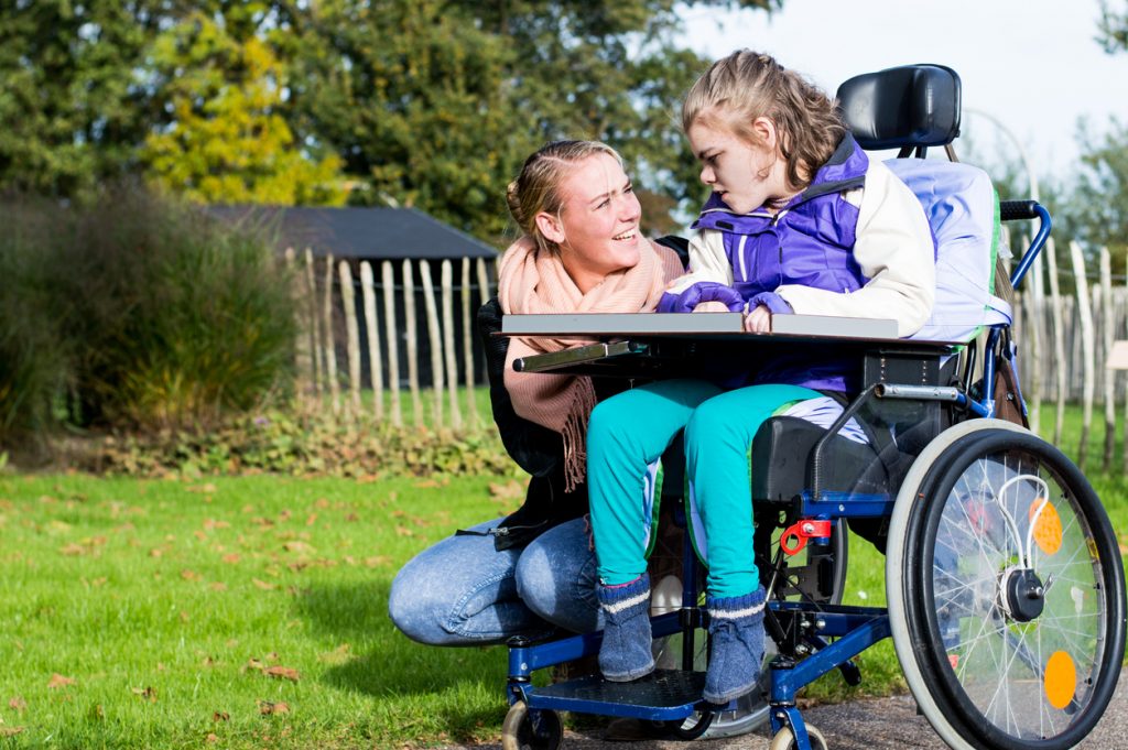 Disability a disabled child in a wheelchair relaxing outside